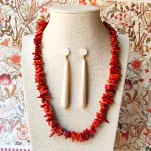 pendientes hueso natural sobre maniquí con un collar de coral