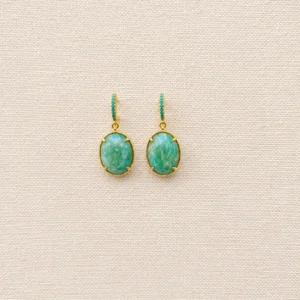 Pendientes dorados y piedra natural verde sobre un fondo blanco, mostrando su diseño elegante y colorido.